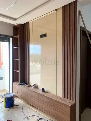 Modern wall-mounted entertainment unit with shelving and wood paneling