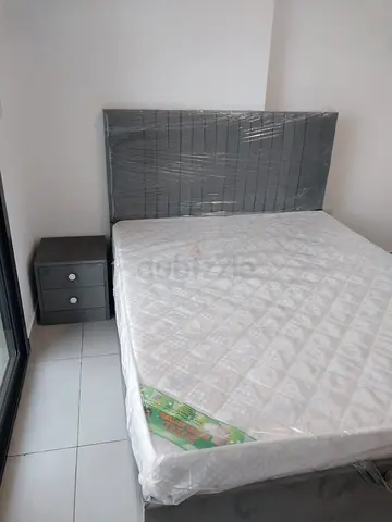 Queen grey upholstered bed frame with mattress and bedside table