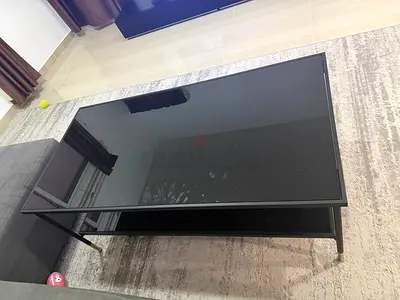 Black glass top coffee table with lower shelf - good condition