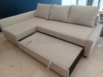 Light grey L-shaped sofa with pull-out bed and storage — good condition