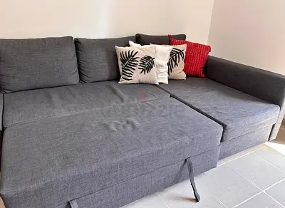 Grey fabric sofa bed with cushions