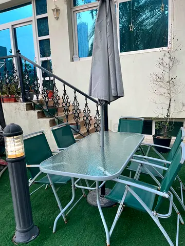 Outdoor glass-top dining table with 5 folding chairs