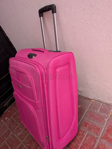 pink, soft-sided suitcase on wheels with a telescopic handle and a combination lock