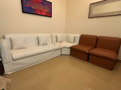 L-shaped white sofa with two brown armless chairs - good condition