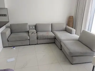 Light grey modular L-shaped sofa with chaise and built-in cup holders
