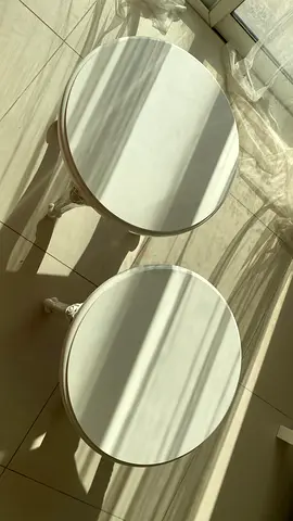 Pair of round white side tables with carved legs