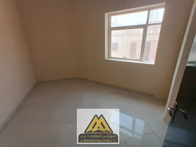 1BR in Al Alia, new building, 2 baths, central AC, near services and Dubai & Sharjah exits, AED 27,997/year.