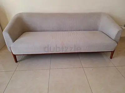 3-seater light grey fabric sofa with wooden legs - good condition comes with the sofa seat cover.
