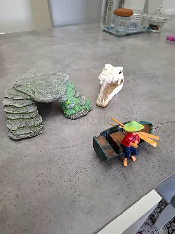 Assorted aquarium ornaments: rock cave, driftwood and small boat decor