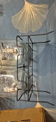 Metal double bottle dispenser stand with two glass jars and taps.