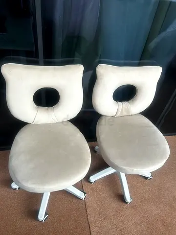 Pair of beige swivel office chairs with cut-out backrest
