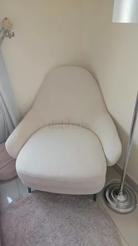 Comfortable off-white lounge chair with curved arms