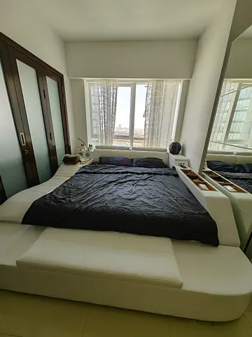 Modern white king bed with built-in storage and headboard shelves