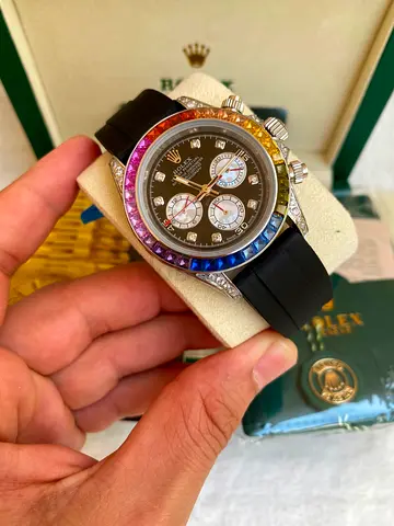 This is a Rolex Daytona Rainbow 40mm watch featuring a rainbow-colored sapphire bezel.