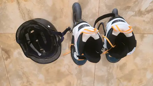 Pair of adult inline roller skates with helmet - good condition, adjustable fit (size 32 to 35).