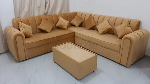 L-shaped beige velvet corner sofa with cushions
