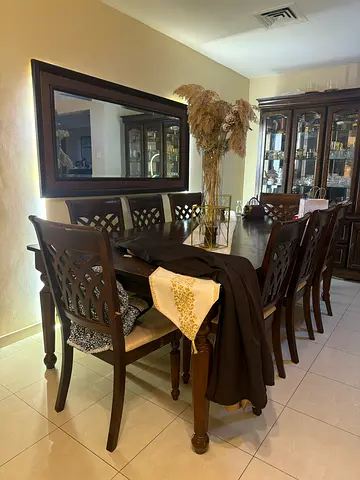 Solid wood 8-seater dining table with carved chairs and display cabinet