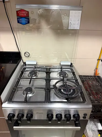 Stainless Steel 4 -Burner Gas Cooker with Oven - Good Working Condition- candy brand - closed door