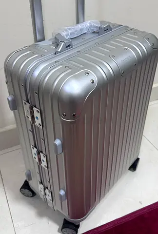Silver hard-shell carry-on suitcase with accents - good condition