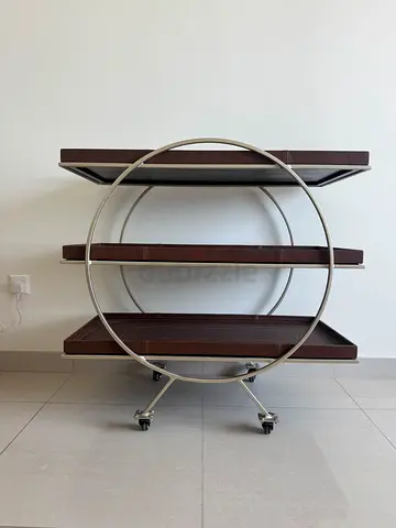 Bespoke modern circular metal frame with leather wrapped wooden shelves on wheels
