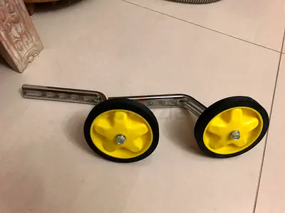 Pair of yellow training wheels for children's bike – adjustable metal brackets