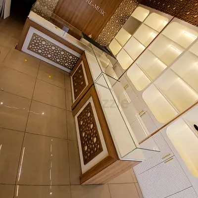 Retail display counter with glass top and illuminated shelving