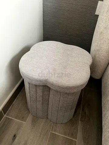 Small light grey ottoman with flower-shaped top