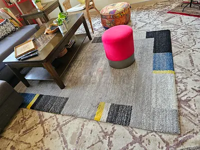 Modern rectangular area rug with geometric border — gently used