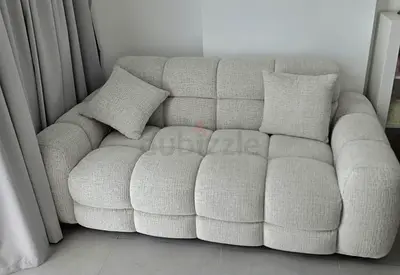 Light grey 2-seater tufted fabric sofa with cushions