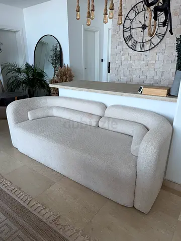 Three-seater cream upholstered sofa in good condition