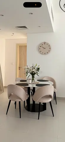 Round -top dining table with 4 beige upholstered chairs