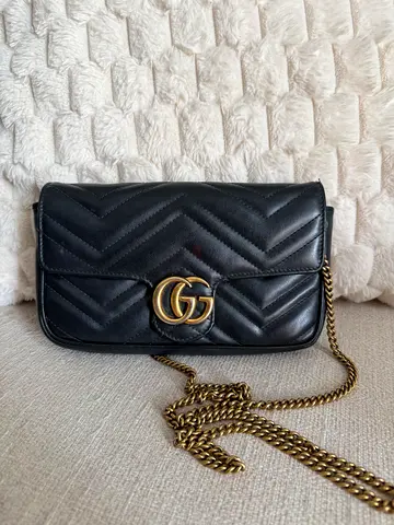 Gucci GG Marmont small shoulder bag in black matelassé leather with gold-toned Double G hardware.
