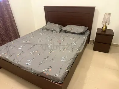 wooden cot with bed and side table