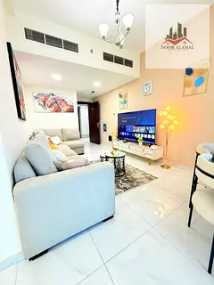 Sharjah, Al Taawun area, two-bedroom apartment with living room, two bathrooms, shower, and balcony.