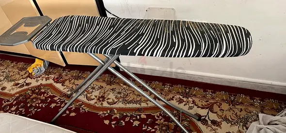 Used adjustable ironing board with cover - good condition