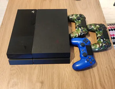 PlayStation 4 console with 3 controllers (2 camo, 1 blue) - good working condition