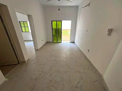 A spacious one-bedroom apartment with a living room and balcony is available for annual rent in Al Muwaihat 2, near Al Shurooq Mall, with an excellent