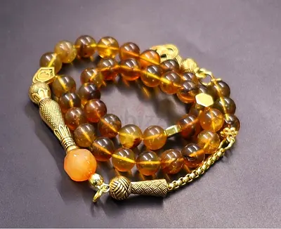 Amber-colored beaded tasbih / prayer beads with gold accents (misbaha)
