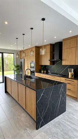 Modern kitchen island with black marble countertop and oak cabinets