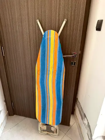 Used ironing board with striped cover, good condition