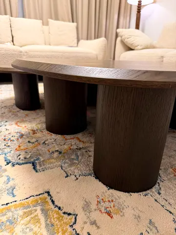 Low oval wooden coffee table with rounded column legs