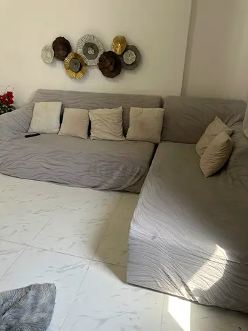 L-shaped grey fabric sofa with cushions - good condition