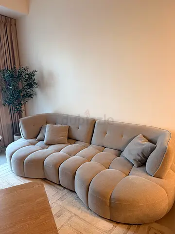 Light grey curved tufted 3-seater sofa in good condition