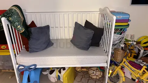 White wooden baby crib with mattress