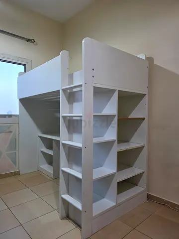 IKEA White wooden bunk bed with built-in study table and storage shelves