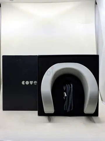 Cove anti-stress wearable device by Feelmore Labs inside its box, accompanied by a USBcharging cable