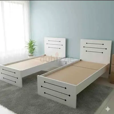 Pair of single white wooden beds with shared nightstand