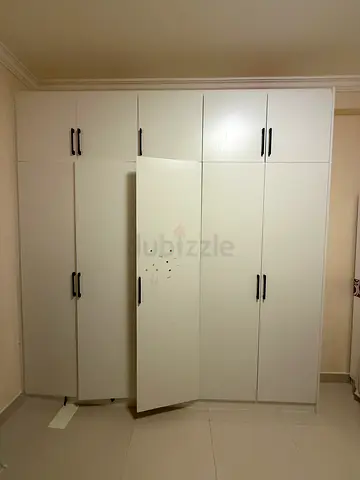 White built-in wardrobe with multiple doors and black handles - good condition