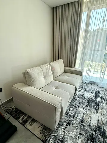 Light beige 3-seater fabric sofa in excellent condition with electrical recliner