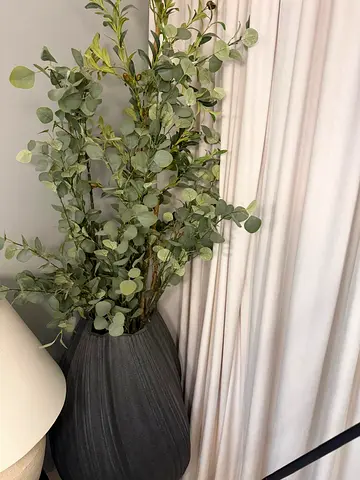 Artificial eucalyptus arrangement in large grey floor vase